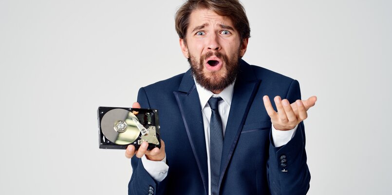 emotional-business-man-suit-gesturing-with-his-hands-disassembled-hard-drive.jpg