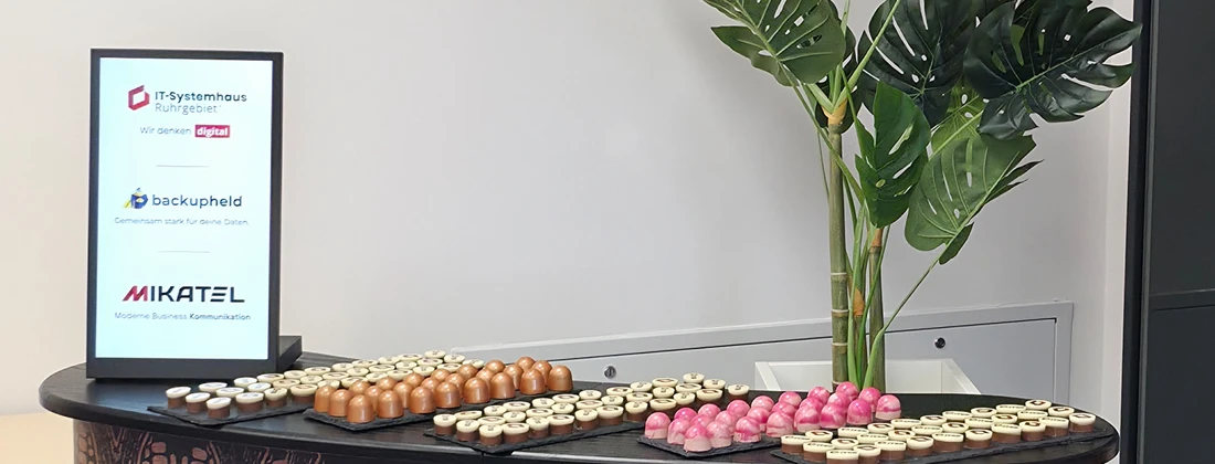 Tisch mit verschiedenen Pralinen und einer Pflanze, präsentiert bei einer Veranstaltung von IT Systemhaus Ruhrgebiet.
