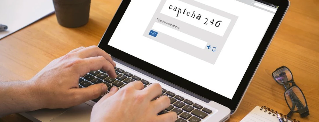 Laptop mit einem CAPTCHA-Formular, das die Eingabe von 'captcha 246' erfordert.