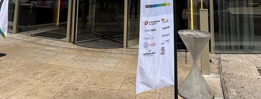 Banner mit Logos von Unternehmen und Organisationen vor einem Gebäude, das für eine Veranstaltung genutzt wird.