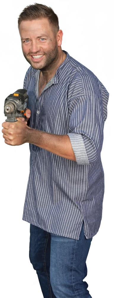 Mann mit einem Bohrer in der Hand, trägt ein gestreiftes Hemd und Jeans, vor grünem Hintergrund.