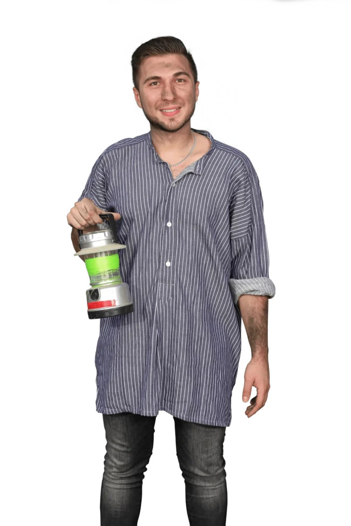 Junger Mann in gestreifter Bluse hält eine grüne und silberne Laterne in der Hand.