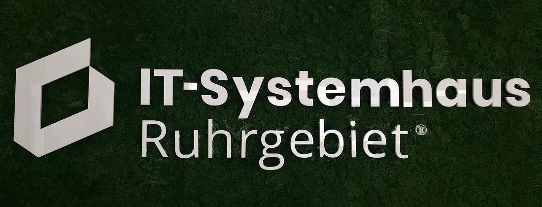 Logo des IT-Systemhauses Ruhrgebiet auf einer grünen Wand mit moderner Schriftart.